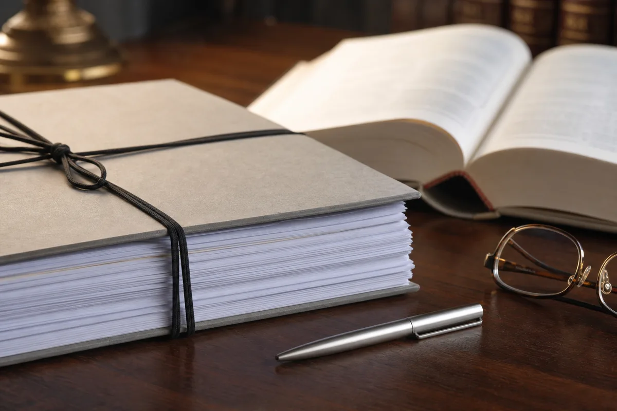 Un exemplaire de pacte d&rsquo;associés posé sur une table de réunion, à côté du Code civil ouvert